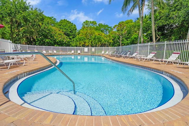 pool with a patio and fence