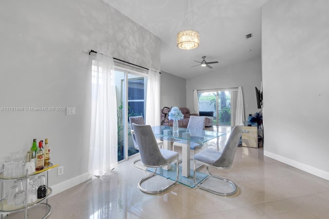 tiled dining area featuring visible vents, a ceiling fan, lofted ceiling, and baseboards