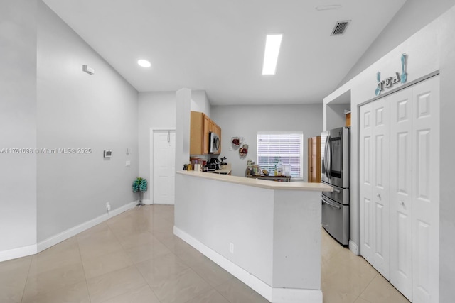 kitchen featuring visible vents, appliances with stainless steel finishes, a peninsula, light countertops, and baseboards