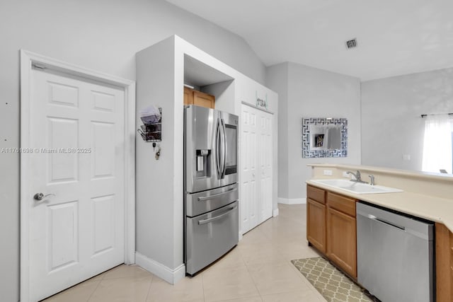 kitchen with visible vents, light countertops, light tile patterned flooring, stainless steel appliances, and a sink