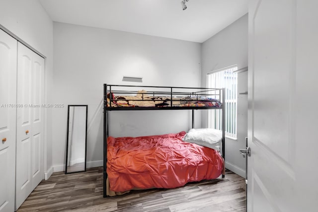 bedroom featuring a closet, baseboards, and wood finished floors