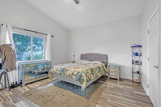 bedroom featuring baseboards, wood finished floors, and vaulted ceiling