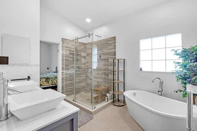 bathroom featuring a sink, a soaking tub, double vanity, and a shower stall