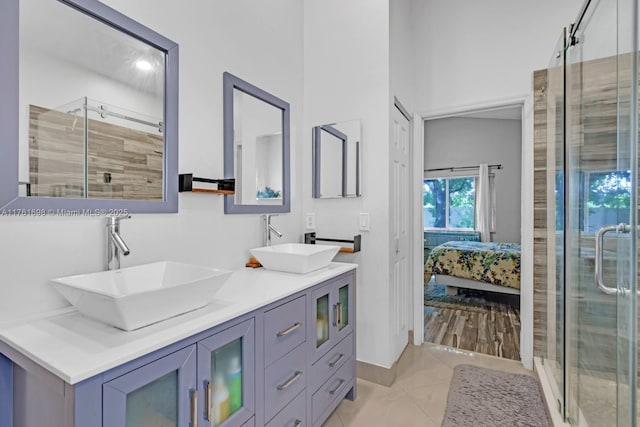 ensuite bathroom featuring a shower stall, tile patterned floors, ensuite bathroom, and a sink