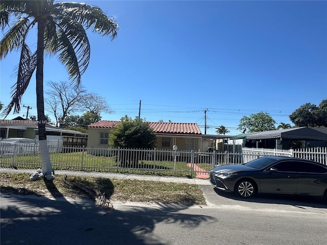 view of front of home with a fenced front yard and a tile roof