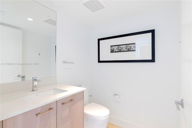 bathroom with visible vents, toilet, and vanity