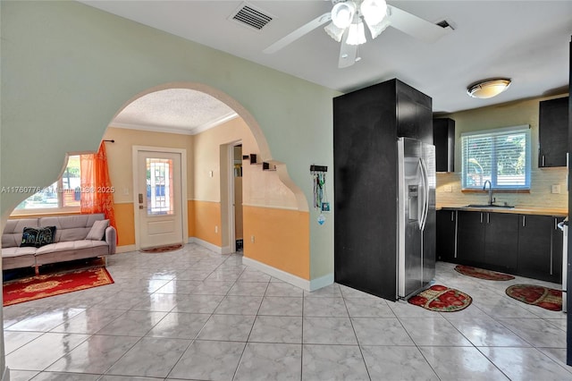 kitchen with light countertops, visible vents, dark cabinets, and a sink