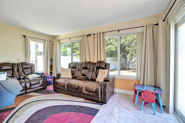 living room featuring light tile patterned floors, baseboards, and plenty of natural light