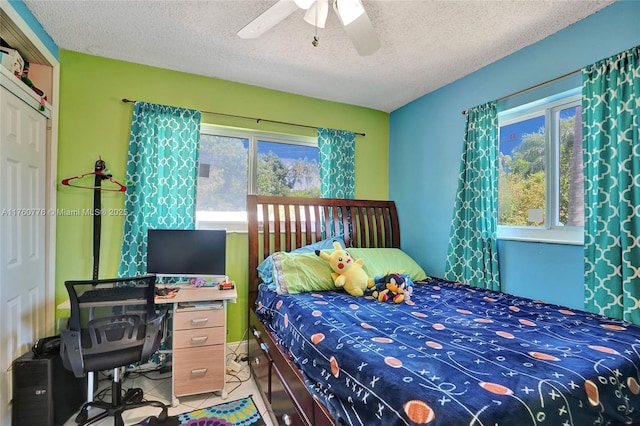 bedroom with light tile patterned floors, a textured ceiling, and a ceiling fan