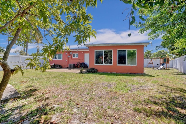 rear view of house featuring stucco siding, a patio, a lawn, and a fenced backyard