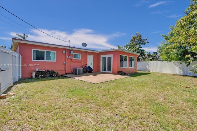 back of property with french doors, a lawn, a fenced backyard, and a patio area