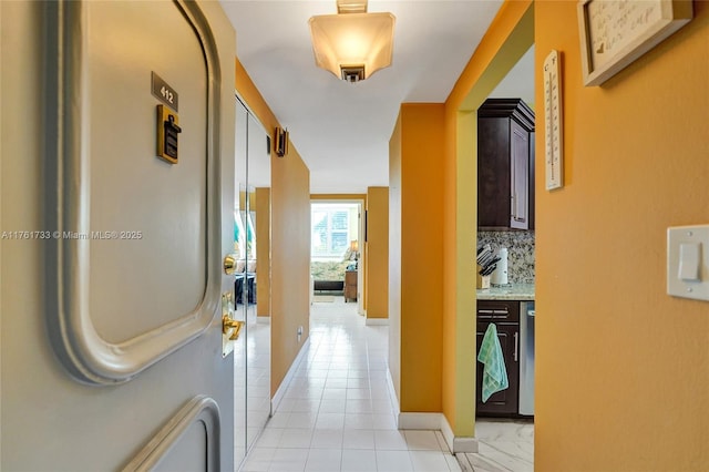 hall with light tile patterned floors and baseboards