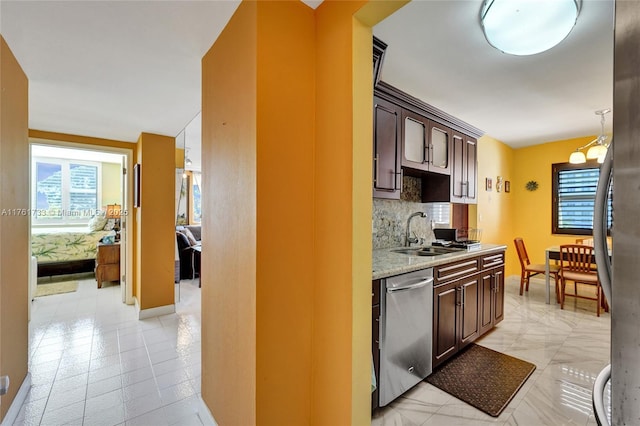 kitchen with a wealth of natural light, dark brown cabinets, appliances with stainless steel finishes, and a sink