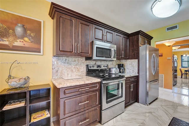 kitchen featuring dark brown cabinets, visible vents, appliances with stainless steel finishes, and decorative backsplash