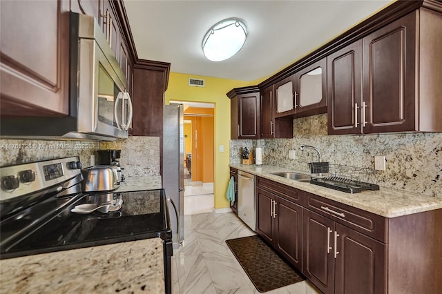 3800 Hillcrest Dr Unit 412, Hollywood, FL 33021 - kitchen with stainless steel appliances, backsplash, dark brown cabinetry, light stone countertops, and baseboards