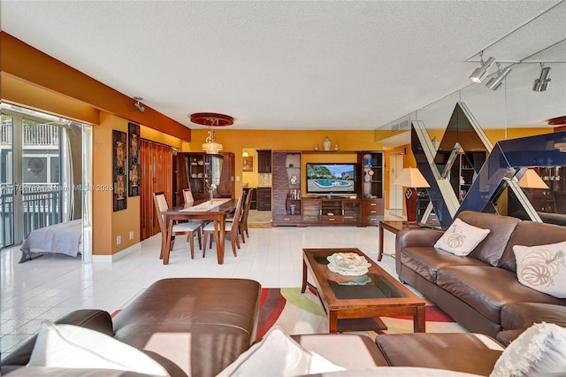 living area featuring visible vents, a textured ceiling, and rail lighting