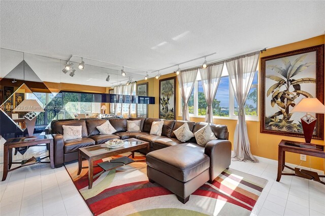 3800 Hillcrest Dr Unit 412, Hollywood, FL 33021 - living room featuring light tile patterned floors, rail lighting, a textured ceiling, and baseboards