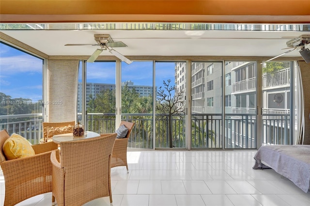 sunroom featuring a city view, a healthy amount of sunlight, and a ceiling fan