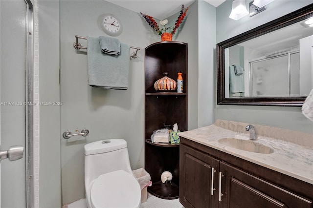 bathroom with a shower stall, vanity, and toilet