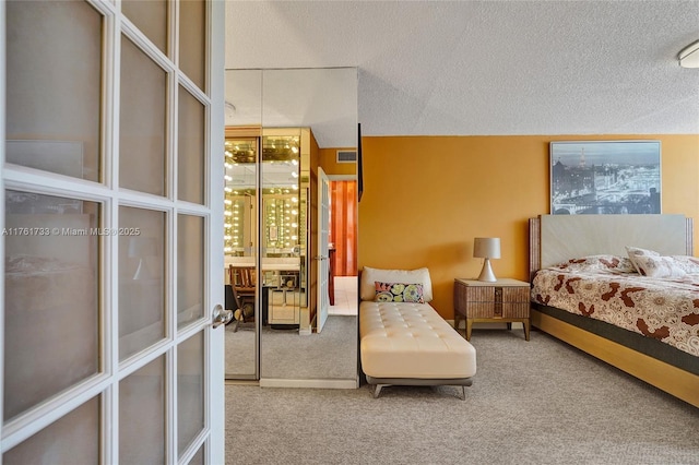 carpeted bedroom with visible vents, french doors, and a textured ceiling