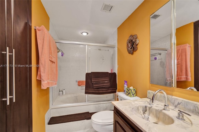 bathroom with enclosed tub / shower combo, visible vents, toilet, and vanity