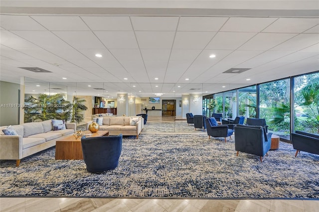 living room featuring recessed lighting, a paneled ceiling, and expansive windows