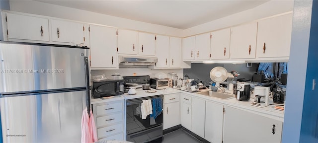 kitchen featuring under cabinet range hood, a sink, electric range oven, freestanding refrigerator, and black microwave