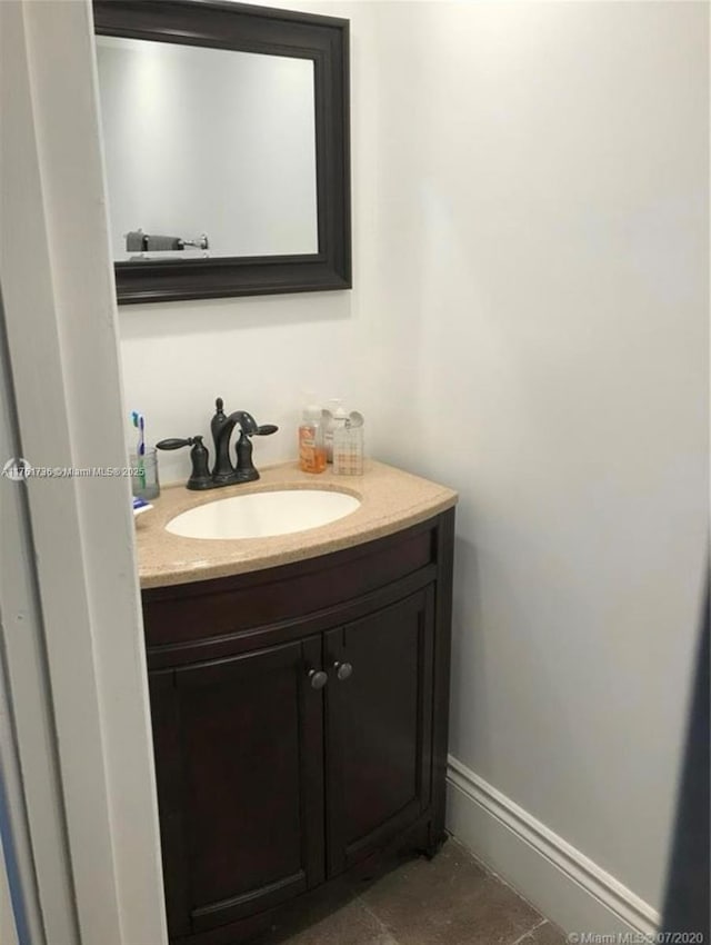 bathroom with vanity, tile patterned floors, and baseboards