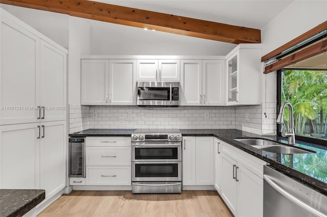 kitchen with a sink, wine cooler, appliances with stainless steel finishes, and white cabinetry