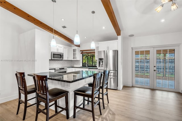 kitchen with visible vents, dark stone countertops, tasteful backsplash, stainless steel appliances, and french doors