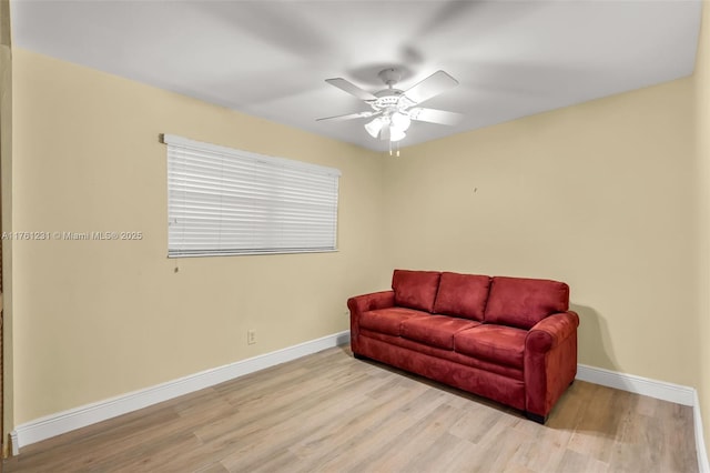 sitting room featuring a ceiling fan, wood finished floors, and baseboards