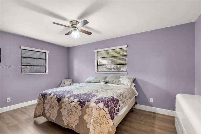 bedroom with ceiling fan, baseboards, and wood finished floors