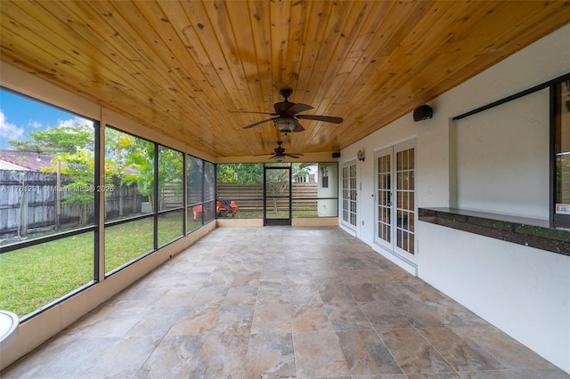 unfurnished sunroom with wood ceiling and a ceiling fan