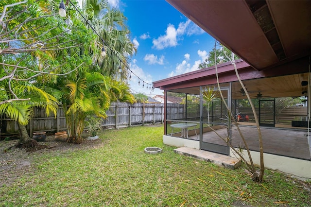 view of yard featuring a fenced backyard, ceiling fan, and a patio