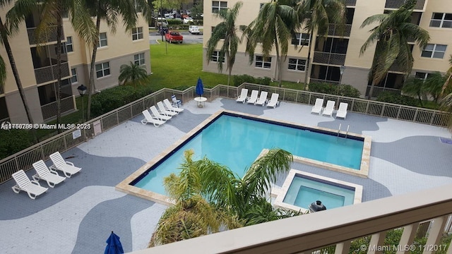 community pool featuring a patio area, a yard, and fence