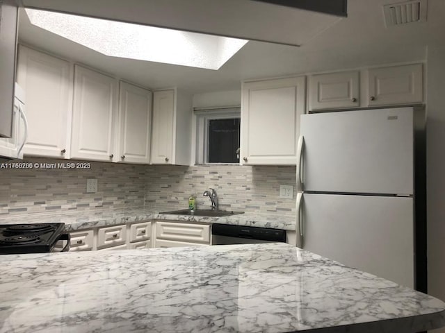 kitchen featuring white appliances, visible vents, a sink, decorative backsplash, and white cabinets