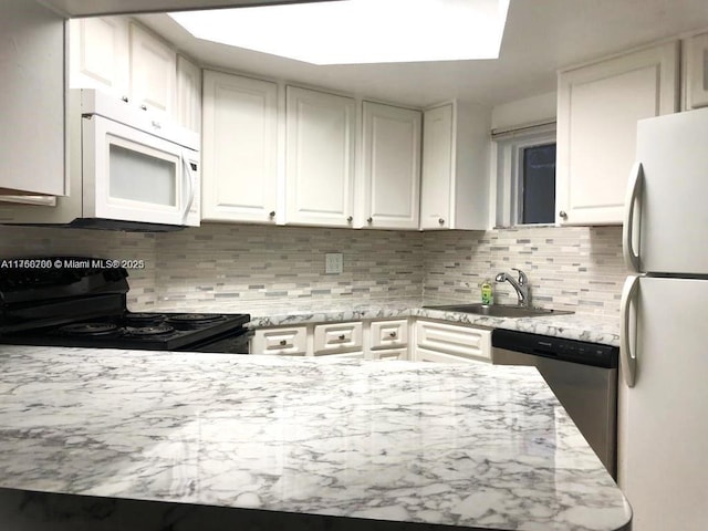 kitchen featuring a sink, decorative backsplash, white appliances, and white cabinets