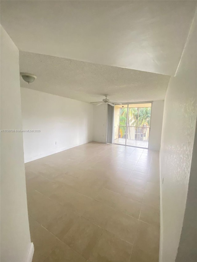 spare room featuring floor to ceiling windows, a textured ceiling, and ceiling fan