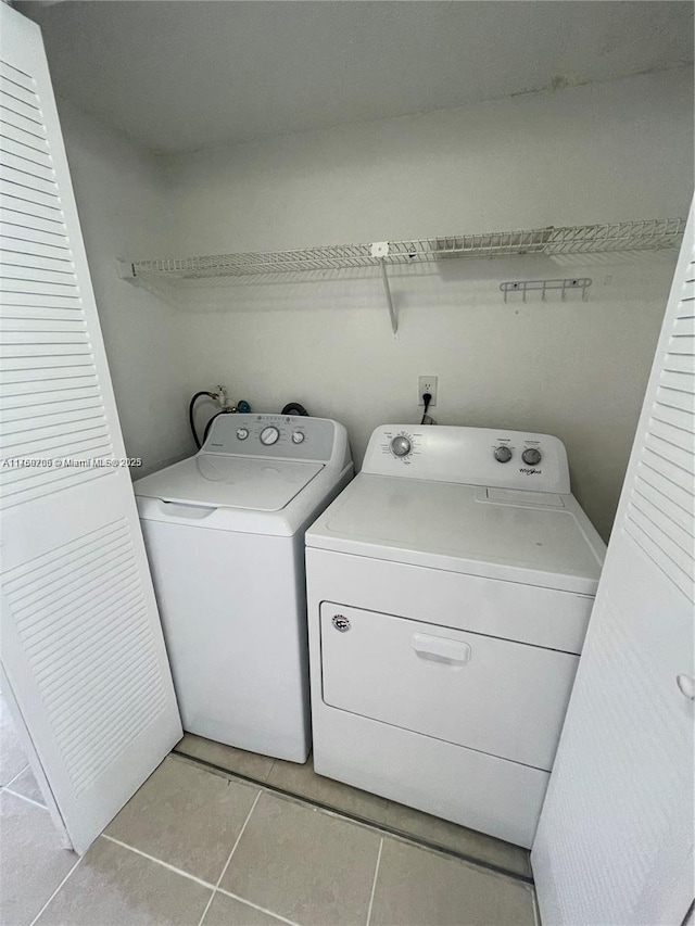 laundry room featuring light tile patterned floors, washing machine and dryer, and laundry area