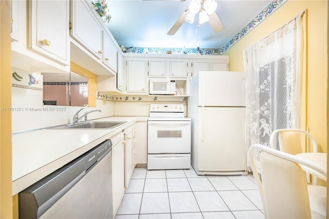 kitchen with white appliances, light tile patterned floors, a sink, light countertops, and white cabinetry