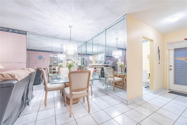 dining space with light tile patterned flooring, a notable chandelier, and a textured ceiling