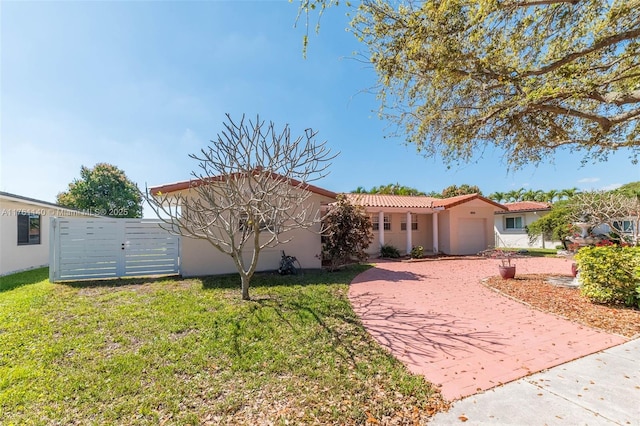 view of front of home with a garage, decorative driveway, a front yard, and stucco siding