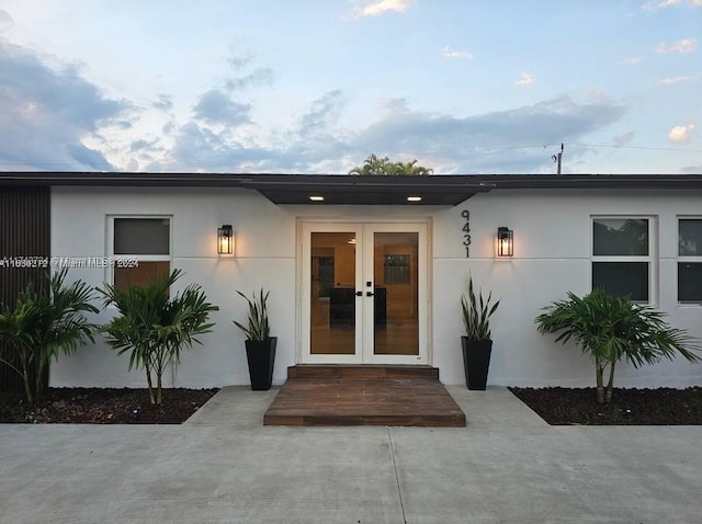 property entrance featuring french doors and stucco siding