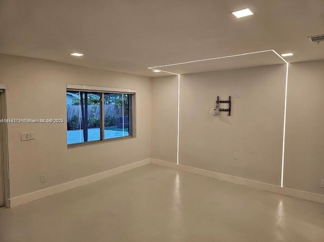 unfurnished room with visible vents, baseboards, and concrete floors