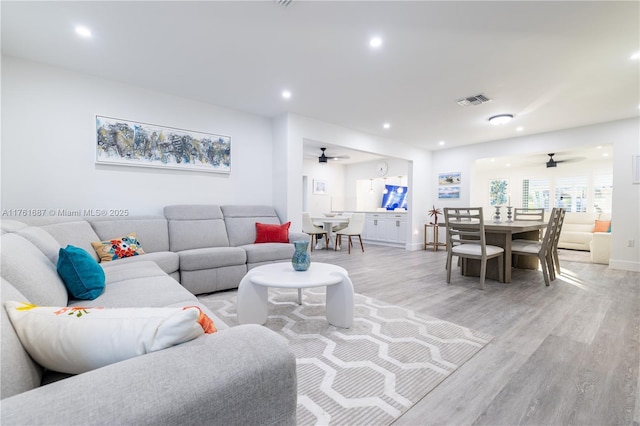 living room featuring light wood-style flooring, recessed lighting, a ceiling fan, and visible vents