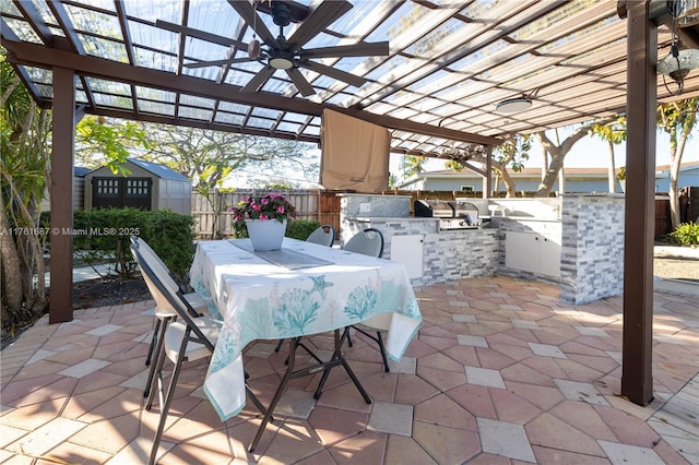 view of patio featuring a storage unit, area for grilling, a pergola, an outdoor structure, and outdoor dining area