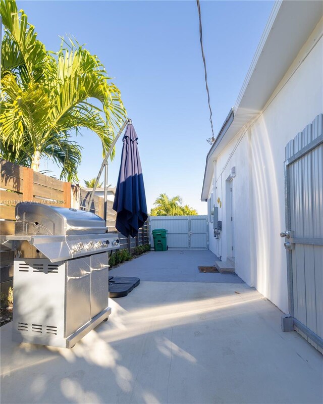 view of patio with area for grilling and fence