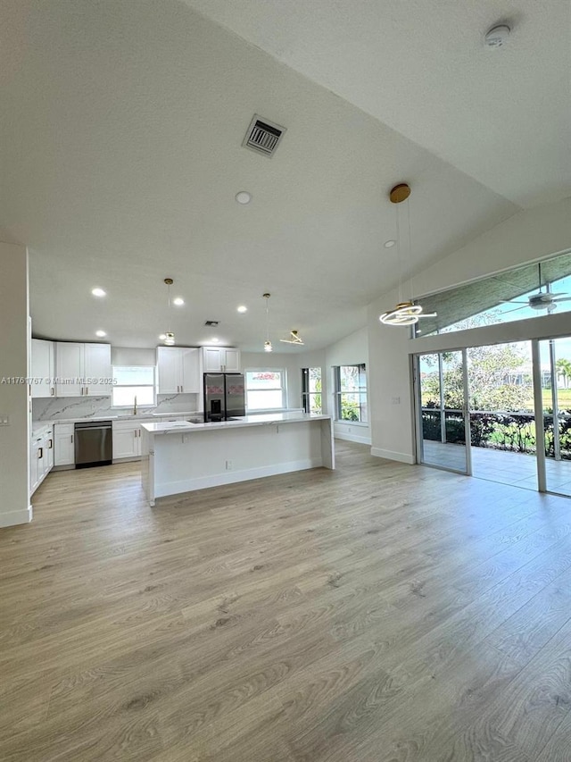 9785 San Luca St, Lake Worth, FL 33467 - unfurnished living room with light wood-type flooring, baseboards, recessed lighting, a ceiling fan, and lofted ceiling