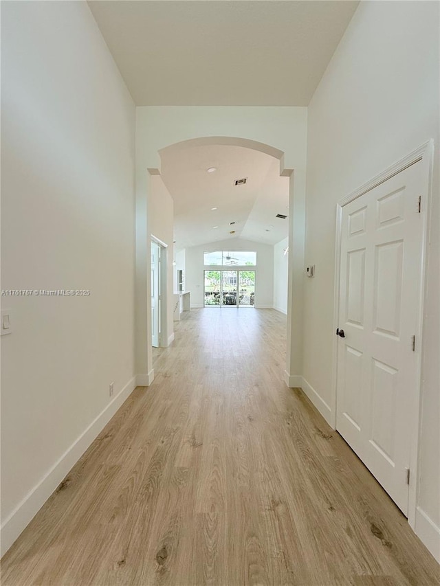 9785 San Luca St, Lake Worth, FL 33467 - hall with vaulted ceiling, light wood-type flooring, arched walkways, and baseboards