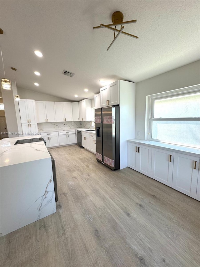 9785 San Luca St, Lake Worth, FL 33467 - kitchen with stainless steel refrigerator with ice dispenser, dishwasher, light wood-style flooring, light stone counters, and white cabinets